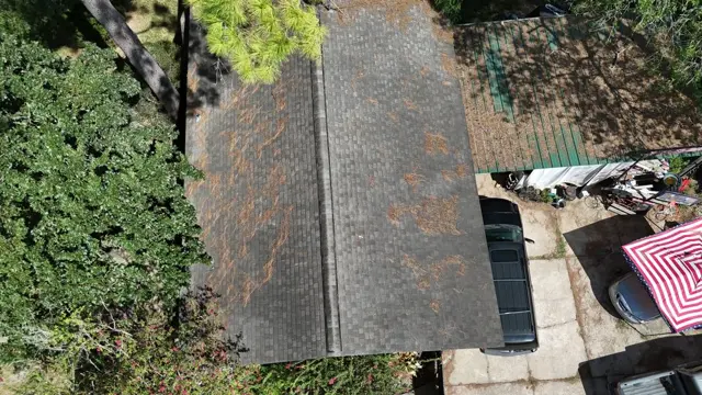 Drone inspection looking straight down the ridge of the Cypress home. Debris streaks across both slopes and the dull, weathered shingle field show a roof near the end of its service life. Aerial inspection photos give the homeowner, and any future insurance underwriter, a clear record of the roof's condition from every angle without walking on brittle shingles.