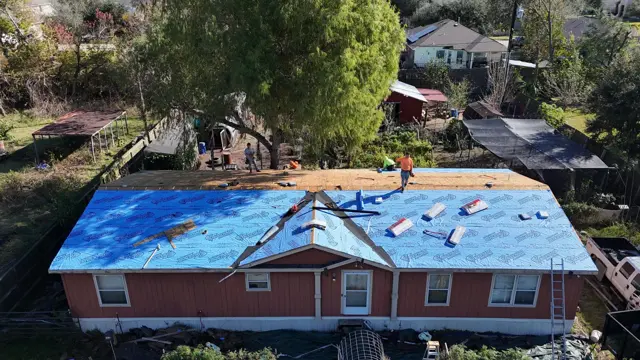 From the drone, the front gable and main roof of the Pearland home are wrapped in synthetic underlayment while the crew works along the ridge. Gables, valleys and the transitions between roof sections are where leaks most often start, so getting underlayment and flashing right in these areas is a key part of a quality roof replacement.
