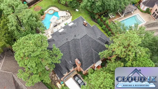 Overhead drone view of the completed reroof on the Spring home: dark charcoal Class 3 impact-rated architectural shingles cover a complex roof with multiple hips, valleys and dormers, with the chimney, skylights and vents all flashed and tied in. Class 3 shingles are rated under UL 2218 to withstand a 1.75-inch steel ball impact, an upgrade in hail resistance for a neighborhood that sees spring hail storms north of Houston.